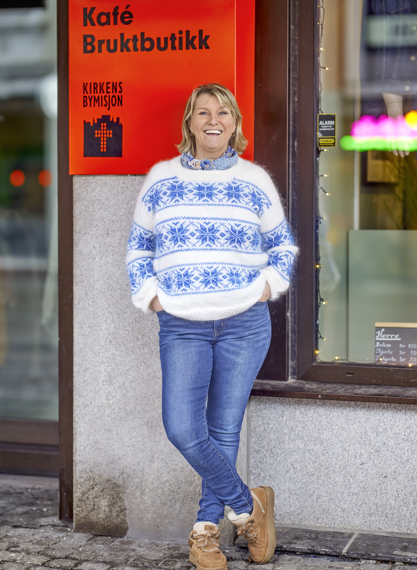 Signe Prøis Tynning ved døren til kaféen og bruktbutikken til Kirkens Bymisjon.