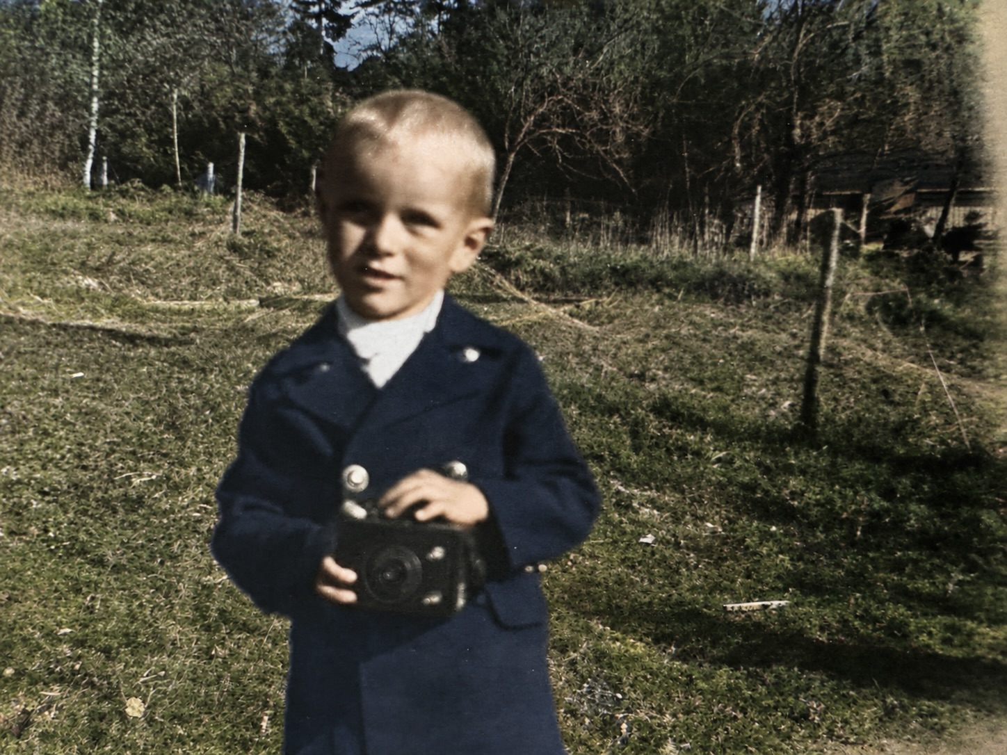 Åsmund som liten gutt på Søndre Valler — med kameraet som skulle bli livsverket ved siden av garden.